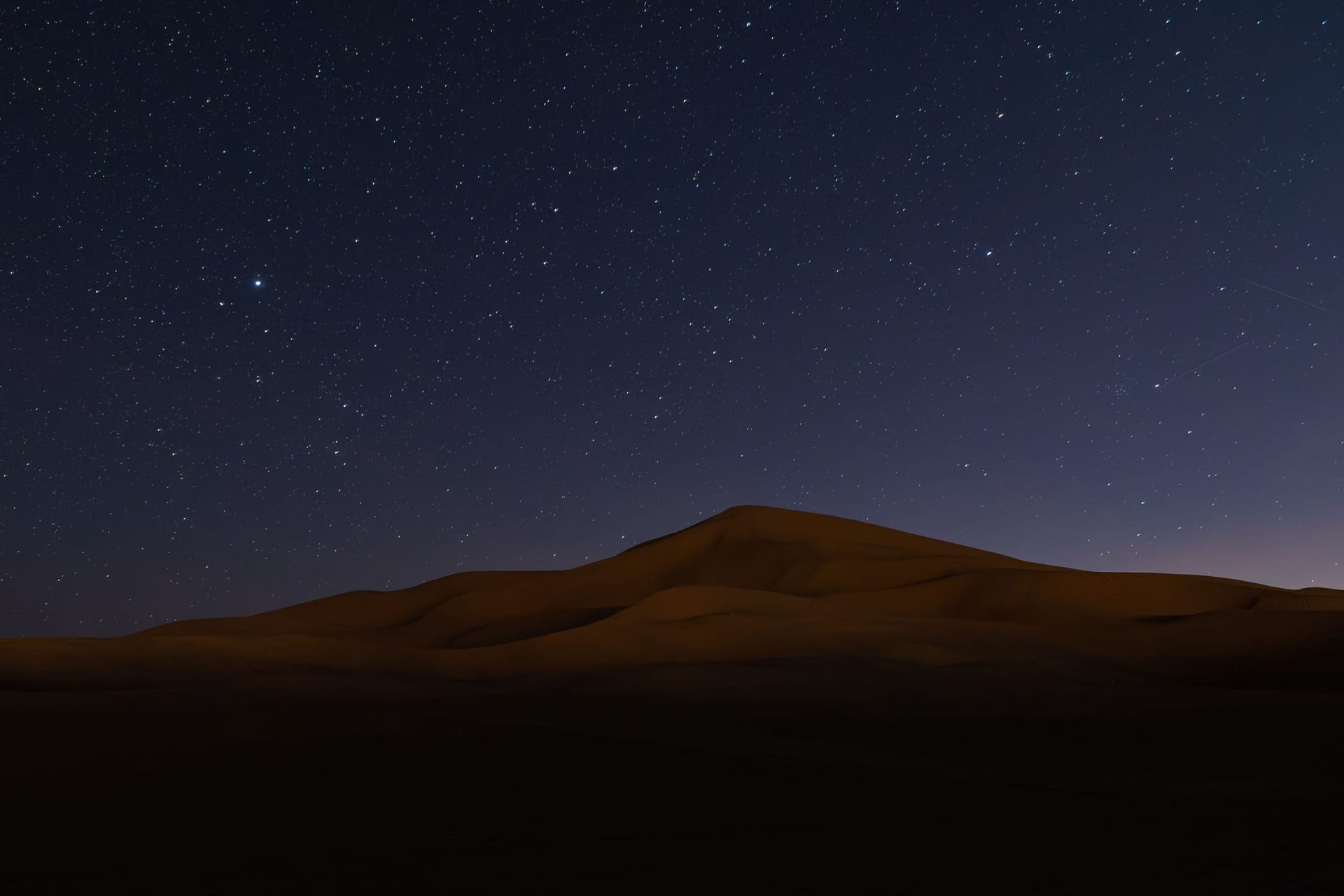 Sahara dunes under a starry night sky in Morocco